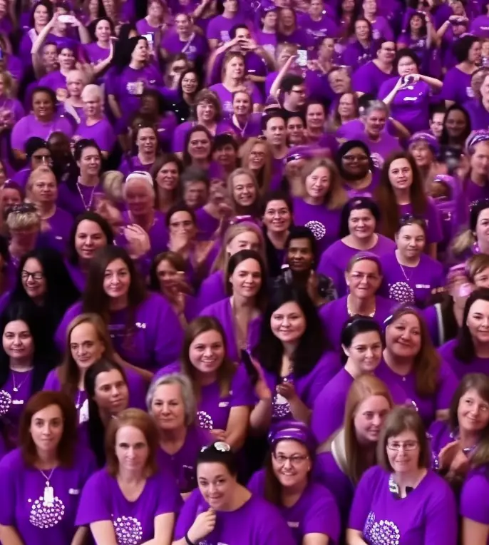 A crowd of smiling people in purple shirts, framed in the PlaceboX D.